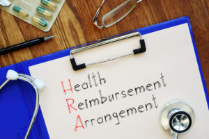 Health Reimbursement Arrangement (HRA) written on clipboard.